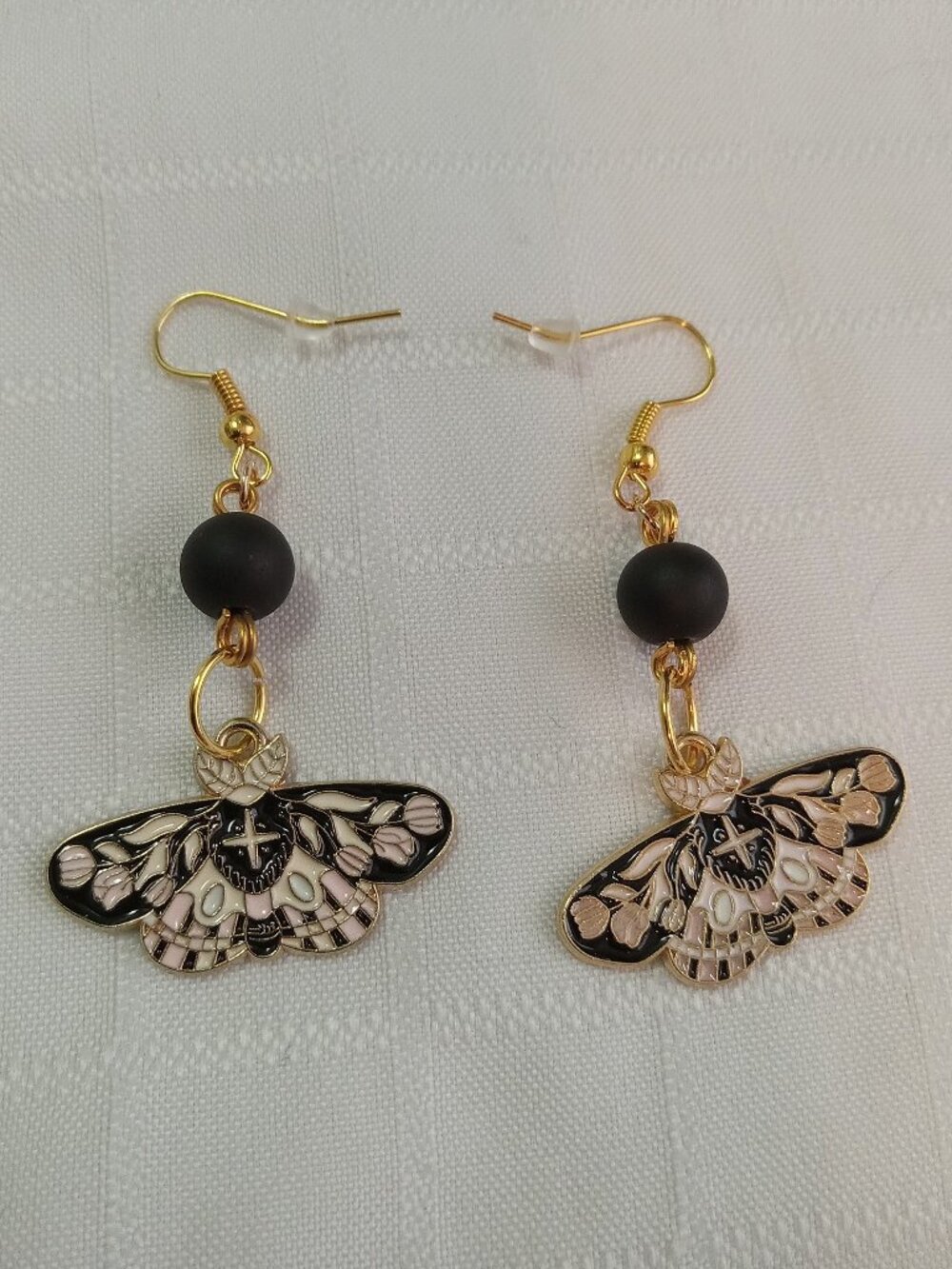 Handmade gold-colored earrings with multicolored enameled butterflies and beads